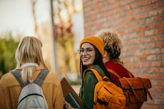 Girl in orange hat walking with fellow students